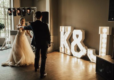 First dance with large lighted letters of initials next to DJ