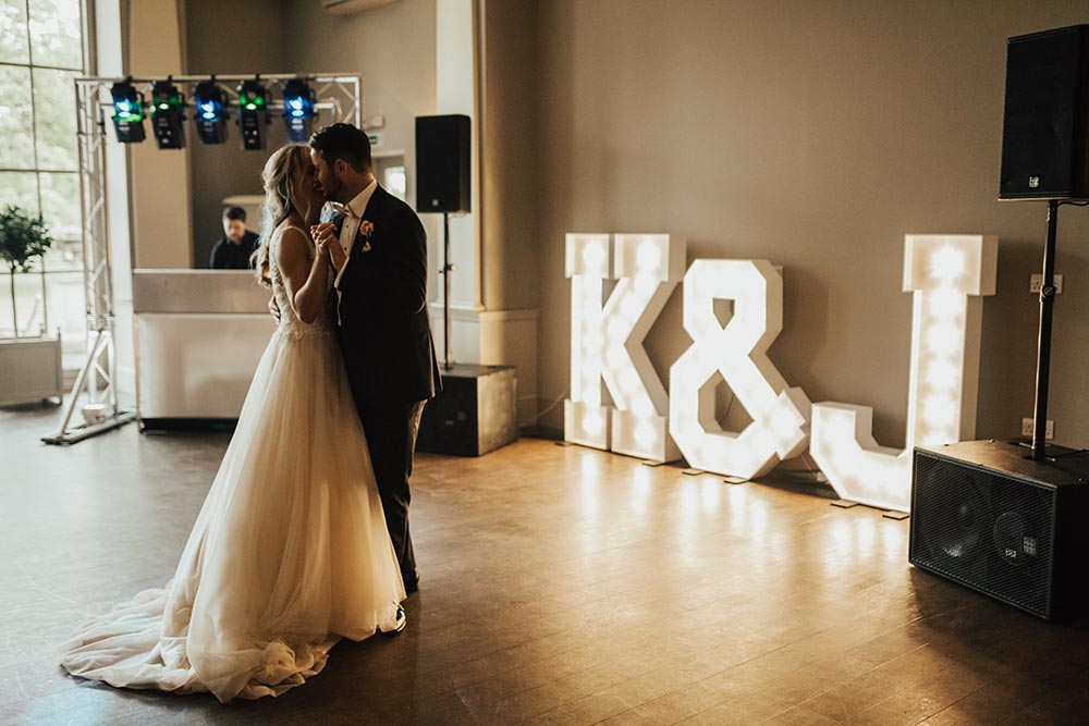 Wedding dance with large lighted letters of couple initials