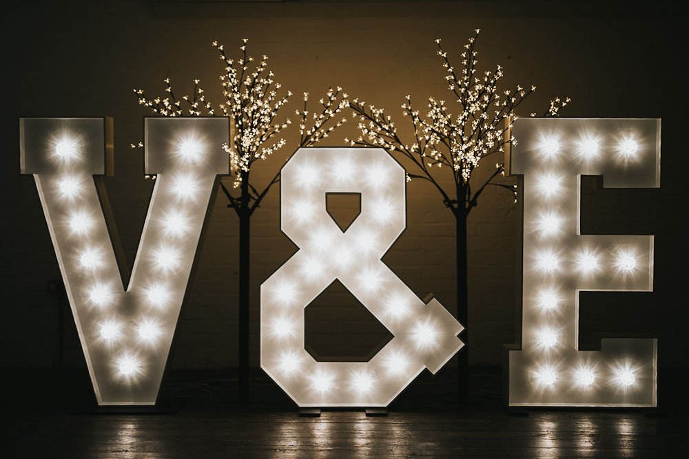 Bride and groom initials in large, lighted letters with 6ft illuminated cherry blossom trees behind