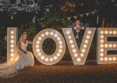 Bride and Groom with large marquee lighted letters of LOVE from Ray of Light Letters, Lincolnshire and Yorkshire